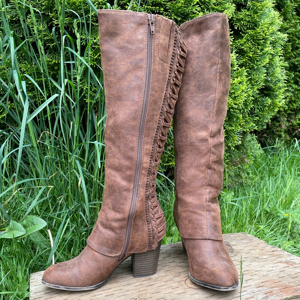 Knee high faux leather brown boots.